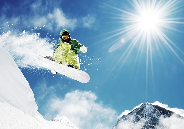 Snowboarder at jump inhigh mountains