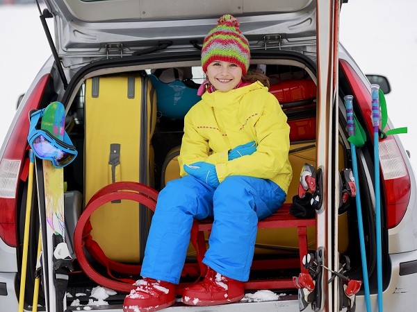 Winter, skiing, journey - girl with ski equipment ready for trav