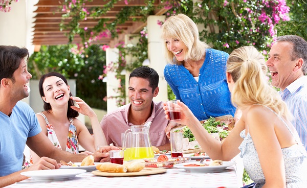 Group Of Young And Senior Couples Enjoying Family Meal