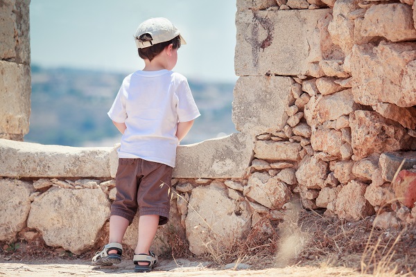 Back view of cute little boy outdoors in city