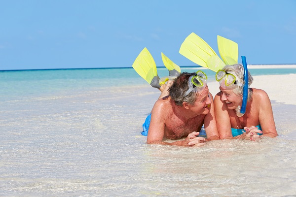 Senior Couple With Snorkels Enjoying Beach Holiday