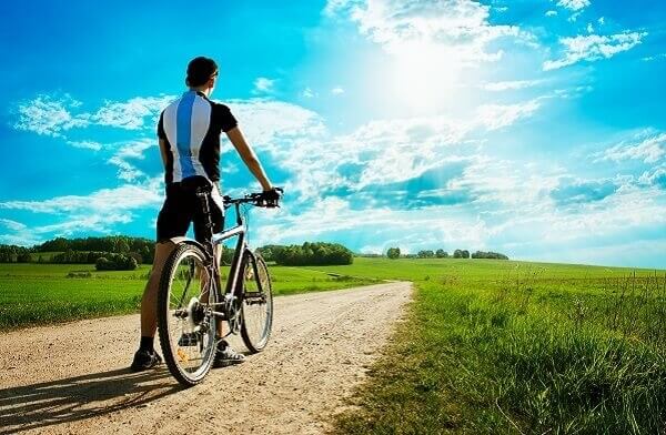 Man cycling through field