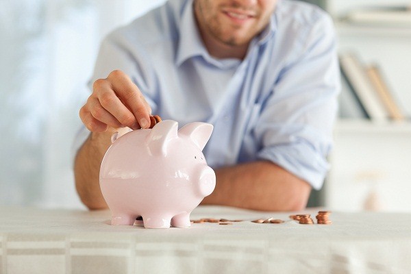 Man putting coins into piggy bank