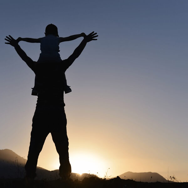 Silhouette of father with son on his shoulders