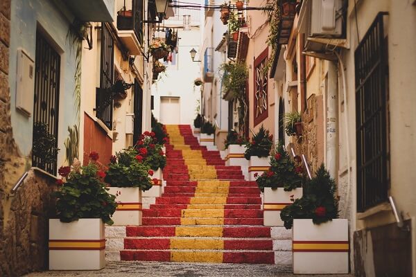 stairs leading up through a street with the spanish flag colours on